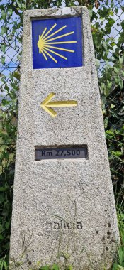 Santiago de Compostela 'ya giden yolu gösteren sarı deniz tarağı kabuğu ve okla mil taşı işareti.