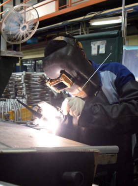 Sidoarjo, Indonesia - April 9, 2015: worker welding material the spare part on the assembly line at bicycle assembly from Indonesia Polygon in Sidoarjo, East Java, Indonesia