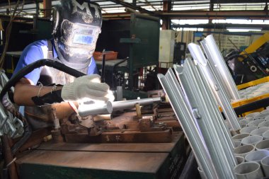 Sidoarjo, Indonesia - April 9, 2015: worker welding material the spare part on the assembly line at bicycle assembly from Indonesia Polygon in Sidoarjo, East Java, Indonesia