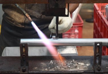 Sidoarjo, Indonesia - April 9, 2015: worker welding material the spare part on the assembly line at bicycle assembly from Indonesia Polygon in Sidoarjo, East Java, Indonesia
