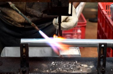 Sidoarjo, Indonesia - April 9, 2015: worker welding material the spare part on the assembly line at bicycle assembly from Indonesia Polygon in Sidoarjo, East Java, Indonesia