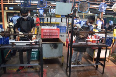 Sidoarjo, Indonesia - April 9, 2015: workers welding material the spare part on the assembly line at bicycle assembly from Indonesia Polygon in Sidoarjo, East Java, Indonesia