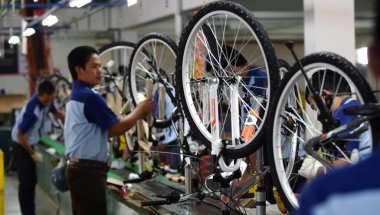 SIDOARJO, INDONESIA - APRIL 9, 2015: Workers check on the assembly line at the assembly bicycle from Indonesia Polygon in Sidoarjo, East Java, Indonesia