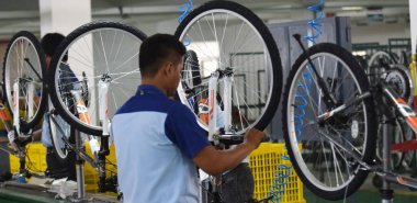 SIDOARJO, INDONESIA - APRIL 9, 2015: Workers check on the assembly line at the assembly bicycle from Indonesia Polygon in Sidoarjo, East Java, Indonesia