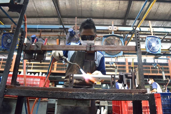 Sidoarjo, Endonezya - 9 Nisan 2015: Doğu Java, Endonezya 'daki Sidoarjo Polygon bisiklet montajının yedek parçası olan işçi kaynak malzemesi