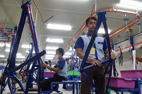 SIDOARJO, INDONESIA - 9 Nisan 2015: İşçiler, Endonezya 'nın Sidoarjo, Doğu Java, Endonezya' daki bisiklet montaj hattındaki montaj hattını kontrol ediyorlar