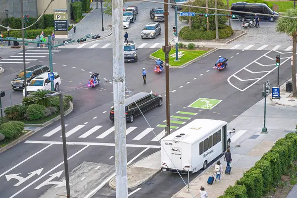 New Orleans, Louisiana ABD 28 Şubat 2025 Polis motosikleti Harley Davidson kavşakta durdu insanlar yürüyordu, elektrik direği, P işareti, limuzin, VIP, limuzin, 