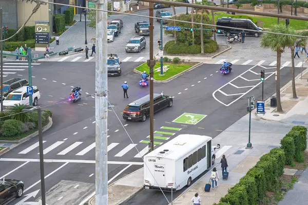 New Orleans, Louisiana ABD 28 Şubat 2025 Polis motosikleti Harley Davidson kavşakta durdu insanlar yürüyordu, elektrik direği, P işareti, limuzin, VIP, limuzin