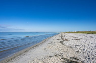 Arka planda Port St. Joe plajı ve batıda Meksika plajı beyaz kum yosunu mavi su ve gökyüzü.