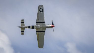 Cosford, İngiltere - 12 Haziran 2022: İkinci Dünya Savaşı 'ndan kalma Consolidated P51 Mustang savaş uçağı mavi gökyüzüne karşı uçuyor. Yakın çekim.