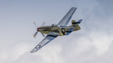 Cosford, İngiltere - 12 Haziran 2022: İkinci Dünya Savaşı 'ndan kalma Consolidated P51 Mustang savaş uçağı mavi gökyüzüne karşı uçuyor. Yakın çekim.