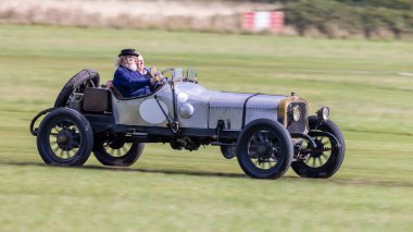 Old Warden, İngiltere - 2 Ekim 2022: Vintage araba 1911 Sunbeam 12 / 16 çimen pisti boyunca hızla sürülüyor