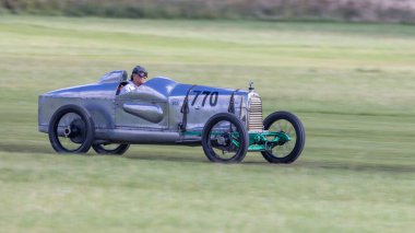 Old Warden, İngiltere - 2 Ekim 2022: Klasik araba 1923 Aston Martin Razor Blade ekip arabası çimen pisti boyunca hızla sürülüyor