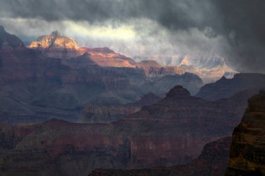 Geçen yağmur fırtınası Arizona 'daki Grand Canyon Ulusal Parkı' nda güneş ışığını filtreleyen bulutlar üretir.