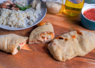 Kasap bloğu yüzeyindeki calzone dilimlerinin yan görünümü