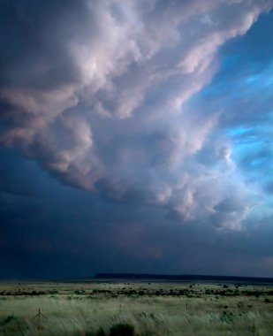 Batan güneşten gelen ışık, Kuzey Arizona 'da geçen bir yağmur fırtınasının renklerini bulutlara yansıtır.