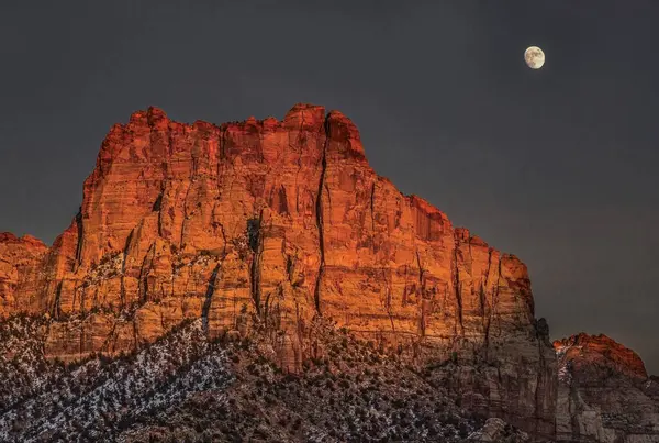 A bright rising moon makes an appearance at Zion National Park, Utah