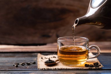 Çay demliğinde sıcak çay fincana dökülüyor, sağlıklı bir içecek.