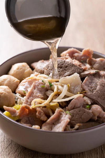 木製の背景にボウルに豚肉と米麺スープ アジア料理 — ストック写真