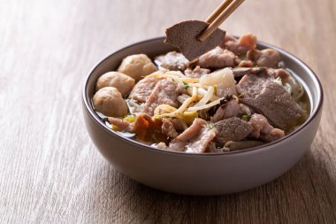 Pirinç eriştesi çorbası, kasede domuz eti, ahşap arka planda yemek çubukları, Asya yemekleri.