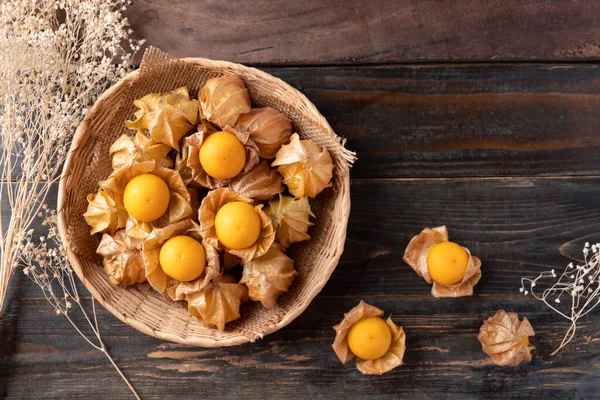 Cape gooseberry or golden berry (Physalis peruviana) in basket on wooden background, Table top view