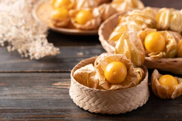 Cape gooseberry or golden berry (Physalis peruviana) in small basket on wooden background
