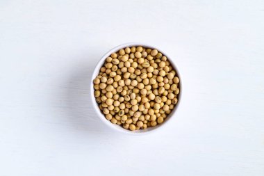 Soybean seeds in bowl on white background, food ingredients high protein good for vegetarian and vegan