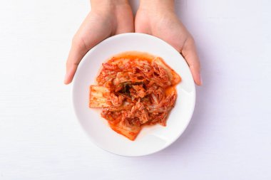 Kimchi cabbage with hand on white background, Korean food homemade side dish, Top view