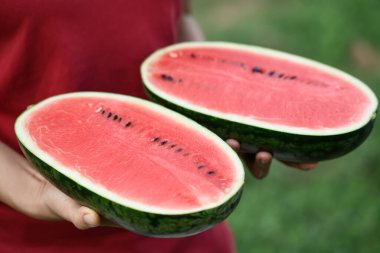 Yaz mevsiminde kadınların elinde yarım karpuz meyvesi, tropik meyve.