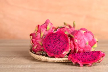 Tahta zeminde kırmızı ejderha meyvesi ya da pitaya sepeti, yaz mevsiminde tropik meyve.