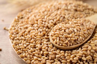 Tabakta tahıllı tahıl, ahşap kaşık, gıda malzemeleri.