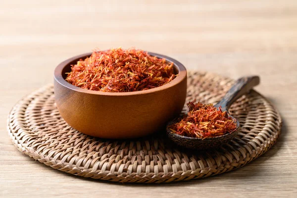 stock image Dried safflower in wooden bowl and spoon, Herbal tea