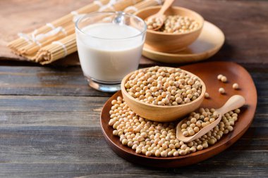 Ahşap zemin üzerinde soya tohumu ve soya sütü, sağlıklı içecek.