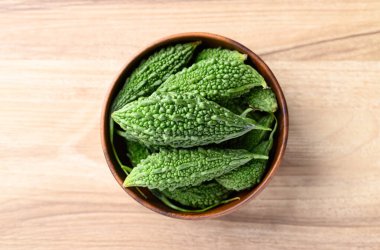 Ahşap arka planda acı kabak veya acı kavun, Asya gıda malzemeleri ve bitkisel ilaç, masa üstü görünümü