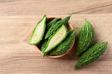 Ahşap arka planda acı kabak veya acı kavun, Asya gıda malzemeleri ve bitkisel ilaç, masa üstü görünümü