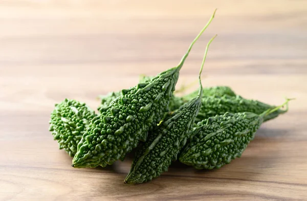 Bitter gourd or bitter melon on wooden background, Asian food ingredients and herbal medicine