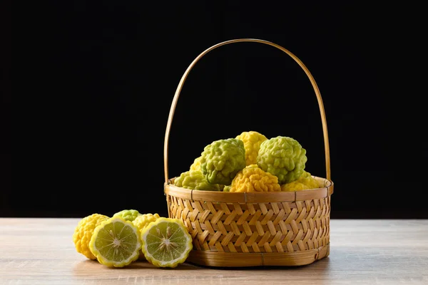 Kaffir lime fruit in basket with black background, Organic ingredients in Thai cuisne, beauty and cosmetics