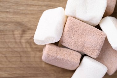 Marşmelov çikolatalı ve vanilyalı, ahşap arka planda, masa üstü manzaralı.