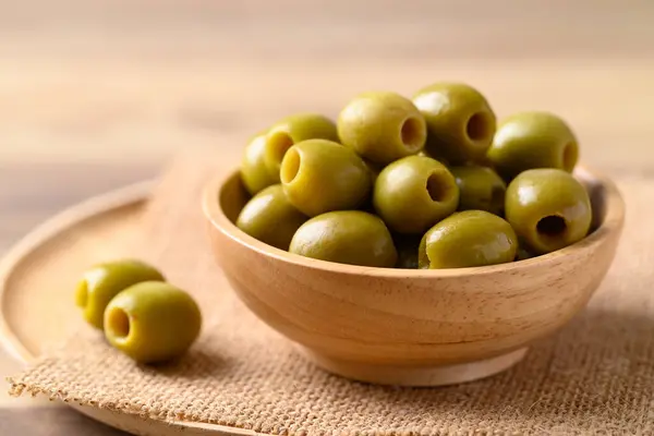 Pickled olives, Pitted green olives in wooden bowl