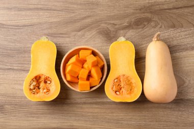 Yarım ve dilimlenmiş kabak kabağı ahşap zemin üzerinde, masa üstü görünümü