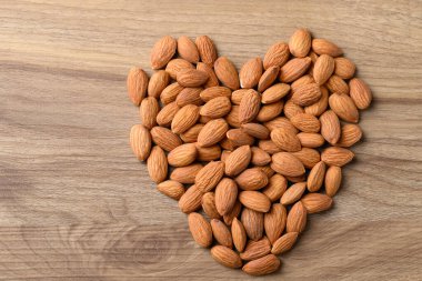 Ahşap zemin üzerinde ham badem (kalp şekli), aşk kavramı