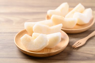 Bir parça Asya armut meyvesi ya da ahşap kasede yemeye hazır Nashi armudu.