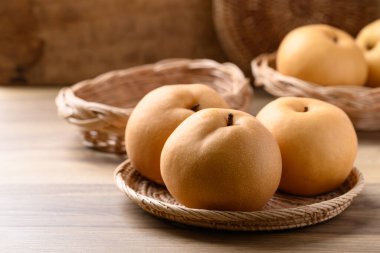 Asya armut meyvesi ya da ahşap armut sepetinde Nashi armudu