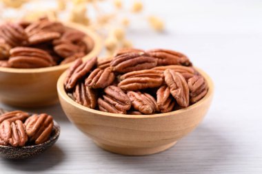 Tahta kasede çiğ ceviz, beyaz masa, yiyecek malzemesi.