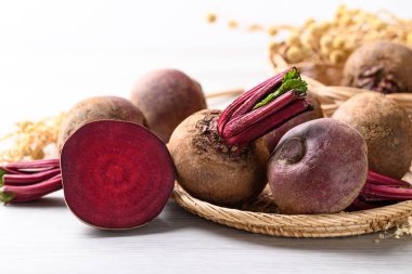 Beyaz arka planda doğal sepette taze pancar kökü, yiyecek malzemesi.