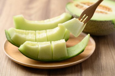 Tahta tabakta, yenmeye hazır yeşil kavun meyvesi.