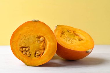 Beyaz üzerine turuncu Hokkaido kabağı, sarı arka plan, sonbahar sebzeleri