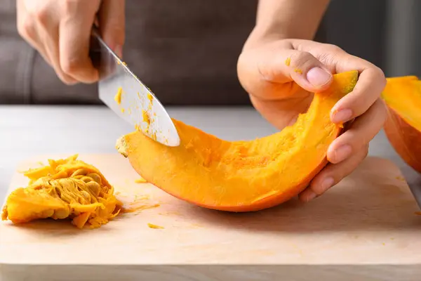 Labu Hokkaido Oranye Dengan Tangan Memegang Pisau Untuk Menghilangkan Biji Stok Lukisan  