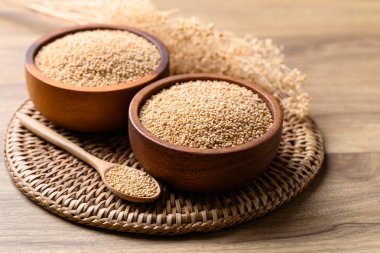 Brown quinoa seed in wooden bowl with spoon, Healthy food ingredient