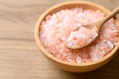 Organic Himalayan pink salt in bowl with spoon on wooden background, Healthy food ingredient